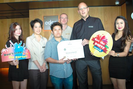 Hilton Pattaya GM Rudolf Troestler (2nd right) presents the grand prize to Ornchuma Watanakorn (front row, 3rd left) as Hilton management and staff help her to celebrate.