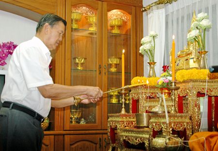 Gen. Kanit Permsub lights incense and candles to pay respects to Lord Buddha.