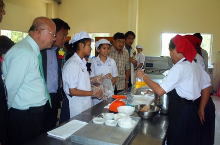 Deputy Mayor Wattana Chantanawaranon (left) looks on as students learn how to bake in the school’s bakery-training facility.