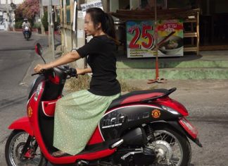 A woman rides her motorbike without a helmet on Central Pattaya Road.