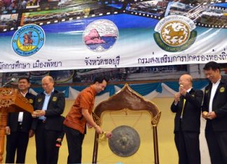 Mayor Itthiphol Kunplome strikes the gong to begin the anniversary party, as other school and city officials look on.