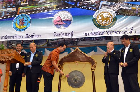 Mayor Itthiphol Kunplome strikes the gong to begin the anniversary party, as other school and city officials look on.