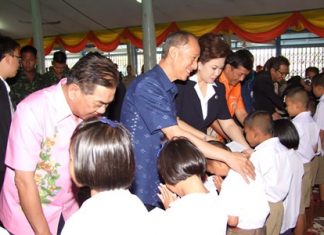 Gov. Khomsan Ekachai (center) and local officials hand out scholarships to deserving students.