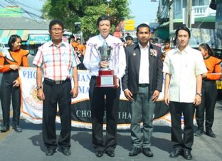 Phothisamphanphitthayakhan Principal Visanu Phasomzup (2nd left) and Saroj Bunmuang (2nd right), consultant on musical strategies for Chonburi Province, joined the 45-piece brass band at Lan Po for a parade on Naklua Road Jan. 16 to show off the HRH Crown Prince trophy.