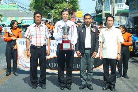 Phothisamphanphitthayakhan Principal Visanu Phasomzup (2nd left) and Saroj Bunmuang (2nd right), consultant on musical strategies for Chonburi Province, joined the 45-piece brass band at Lan Po for a parade on Naklua Road Jan. 16 to show off the HRH Crown Prince trophy.