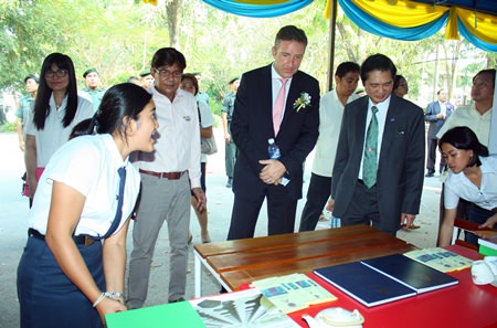H.E. Enno Drofenik (center), Ambassador Extraordinary and Plenipotentiary of the Republic of Austria, and Watcharin Siriphanit (right), director of the Thai - Austria Technical College, listen to students presenting their inventions.