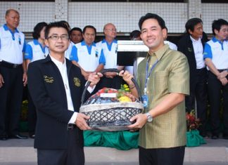 Pattaya City Manager Pakorn Sukonthachart (left), representing Pattaya officials and employees, gives a Happy New Year gift basket to Mayor Itthiphol Kunplome (right).
