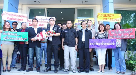 Pattaya Tour Guide Club president, Krittidet Suttichotipunya (3rd left, with flowers), along with a group of tour guides, file a complaint with DSI Deputy Director-General Phermphun Phungprasit (4th left), and DSI Eastern Operation Center Director Prawit Chaibuadaeng (5th left), regarding illegal foreign tour guides.