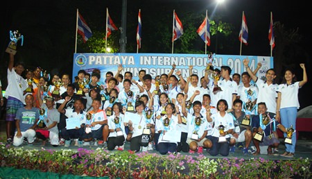 Windsurfing champs hold their trophies aloft following the prize-giving ceremony on Jan. 12 at Jomtien beach.
