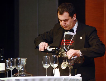 Българският сомелиер Вихрен Велков умело налива бутилка тракийско вино.