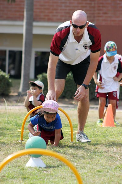PE Teacher Mr Rudling gives a helping hand to a Blue House student.