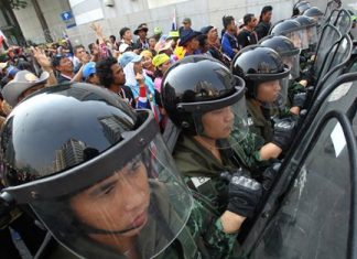 Thai soldiers stand guard to block anti-government protesters, left, during a rally outside the office of the permanent secretary for defense where Prime Minister Yingluck Shinawatra was reportedly working inside Monday, Feb. 3, in Bangkok. Around the country, the vast majority of voting stations were open and polling proceeded relatively peacefully, but the risk of violence remained high a day after gun battles in Bangkok left seven people wounded. Meanwhile, protesters vowed Monday to stage larger rallies in central Bangkok and push ahead their efforts to nullify the results of elections that were expected to prolong a national political crisis. (AP Photo/Sakchai Lalit)