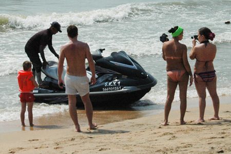 A young Russian tries to negotiate the price for alleged damage to the jet ski while his girlfriend takes photos.