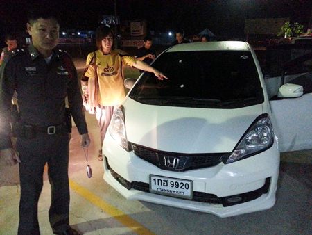 Dusit Thunprasert points to where a bullet entered his car through the windshield.