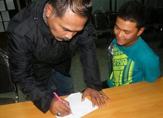 Montree Attavijit is questioned by police after shooting his handgun into the air (seated).