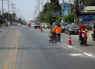 City workers repaint dividing lines on Thepprasit Road, the beginning of a citywide repainting project.