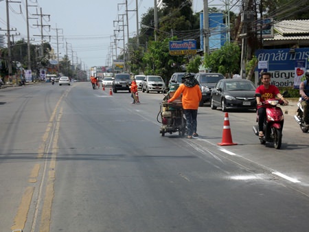 City workers repaint dividing lines on Thepprasit Road, the beginning of a citywide repainting project.