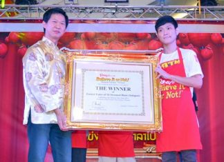 Somporn Naksuetrong (left), manager of Ripley’s Pattaya, presents the winning plaque to Akharin Jatuporn.