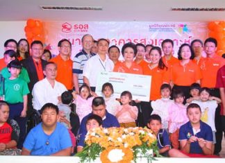 Angkhana Pilanowat Chimanas (center right), MD of the Government Housing Bank, presents a 100,000 baht donation to Father Pattarapong Srivorakul (center left), president of the Father Ray Foundation, to add to the vocational training building fund.