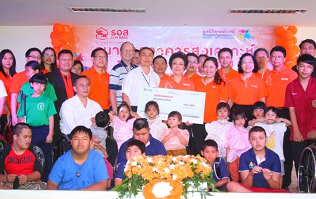 Angkhana Pilanowat Chimanas (center right), MD of the Government Housing Bank, presents a 100,000 baht donation to Father Pattarapong Srivorakul (center left), president of the Father Ray Foundation, to add to the vocational training building fund.