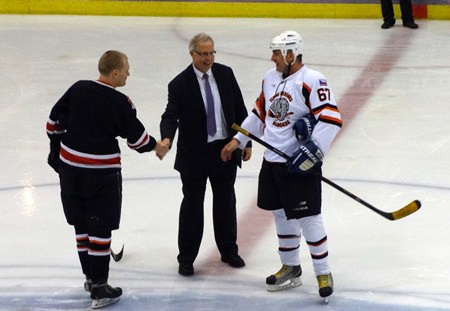 Canadian ambassador Philip Calvert (center) prepares to drop the puck at the opening face-off. (Photo/Julie Lestage)