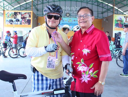 Kittisak Montkaew (right), deputy permanent secretary of Pong municipality, presents a medal to Deputy Mayor Verawat Khakhay (left) for finishing the 10 km distance.