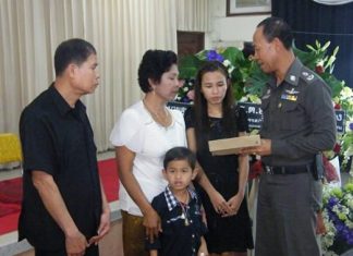 Pol. Maj. Gen. Khatcha Thatsart (right) presents the widow, her son and the deceased’s parents with official compensation for the policeman’s death.