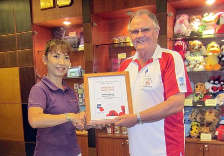 Derek Brook (right), on behalf of the Royal British Legion Thailand, presents a certificate of appreciation to the staff at Khao Kheow Country Club.