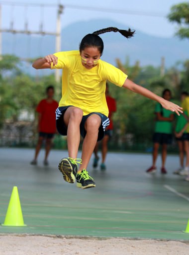 A GIS student leaps during the long jump.