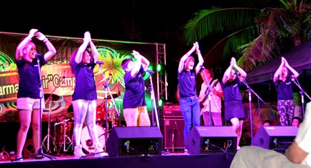 Students perform international choral music on stage.