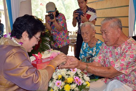Yani Lerdkrai pours lustral water into the palms of respected elders.