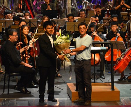 Gregory Barton, president of Pattaya Classical Music, presents Thossaporn Sombat with a token of appreciation.