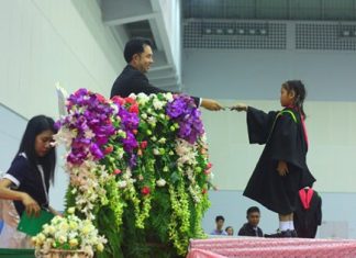 Mayor Itthiphol Kunplome presents a graduation certificate to one of over 2,000 students on March 18 at Pattaya’s at Indoor Stadium.
