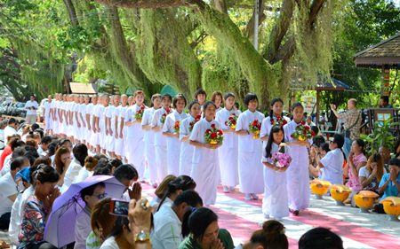 Students participating in the ceremony march in to receive monk robes from guardians and parents.