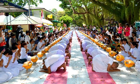 “Dhmmakaya naga” (people about to be ordained as a Buddhist monk) bow to pay respect to their families.