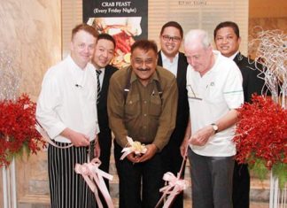 Pattaya Mail Media Group Managing Director Peter Malhotra (center) cuts the ribbon to officially launch the new Crab Feast Fridays, watched by Executive Chef Alistair Carter (front left), Dr Iain Corness (front right), and (back row, left to right) F& B Manager Pansak Pornwisawaraksakul, Tanaphol Rodpinyo, associate director of sales, and Pin Krasang, director of catering.