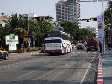This tourist bus just drives straight through the red light without stopping as tourists wait to cross the road.
