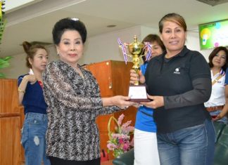 Rotary Club of Chonburi Past President Naree Jintananon (left) presents the Pattaya Mayor Itthipol Khunplome Championship trophy to Aabngern Tripong of the McDao team.