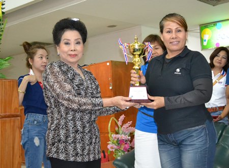 Rotary Club of Chonburi Past President Naree Jintananon (left) presents the Pattaya Mayor Itthipol Khunplome Championship trophy to Aabngern Tripong of the McDao team.