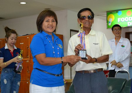 Rotary Club of Plutaluang President Bharni Hokka Left) chairperson of the charity bowling tournament presents the 1st runner-up team trophy to Commander Udon Phadung-ut.