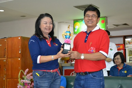 Rotary Club of Plutaluang Charter President Sumon Jaikid presents a trophy to Somchai Poksub.