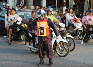 Volunteer Manit Bantherng directs traffic during peak hours in Soi Nernplabwan.