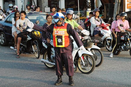 Volunteer Manit Bantherng directs traffic during peak hours in Soi Nernplabwan.