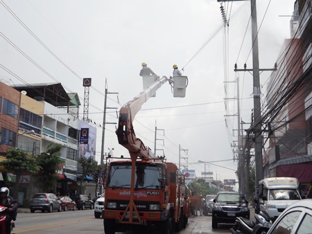 Pattaya Provincial Electricity Authority workers clean Pattaya power lines to prevent outages and fires during rainy season.