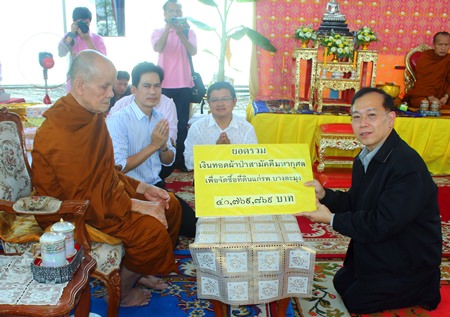 Phra Khru Vibun Thammakit, former abbot of Wat Chonglom, presents over 41 million baht to Visit Tangnapakorn, ombudsman of the Ministry of Public Health, representing Banglamung Hospital.
