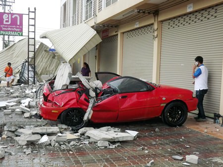 At press time, it is unknown who owned this little red Ford Aspire, but luckily no one was inside this when bricks fell on it from above.  Ubon Kaewkoon’s damaged pickup is behind the fallen canopy in the background.