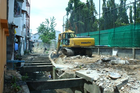 A city mandated backhoe works to expand the canal behind Soi Marine.