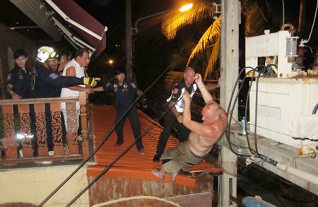 Police and rescuers watch as Lund jumps down off the roof holding the cables after workers had cut off the power.