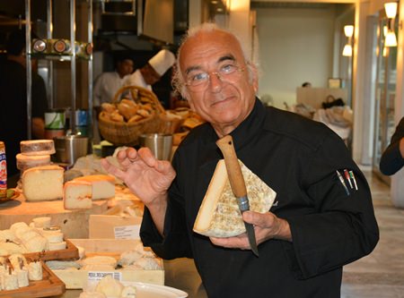 Master cheese maker Gerard Poulard poses for the camera with his trusty knife that can cut the cheeses without leaving the slightest residue on the blade.