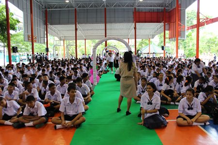 Students at Phothisamphan Phitthayakhan School participating in the activity walk through the school’s “white fence” with their flowers, as white is the signature color of the school.